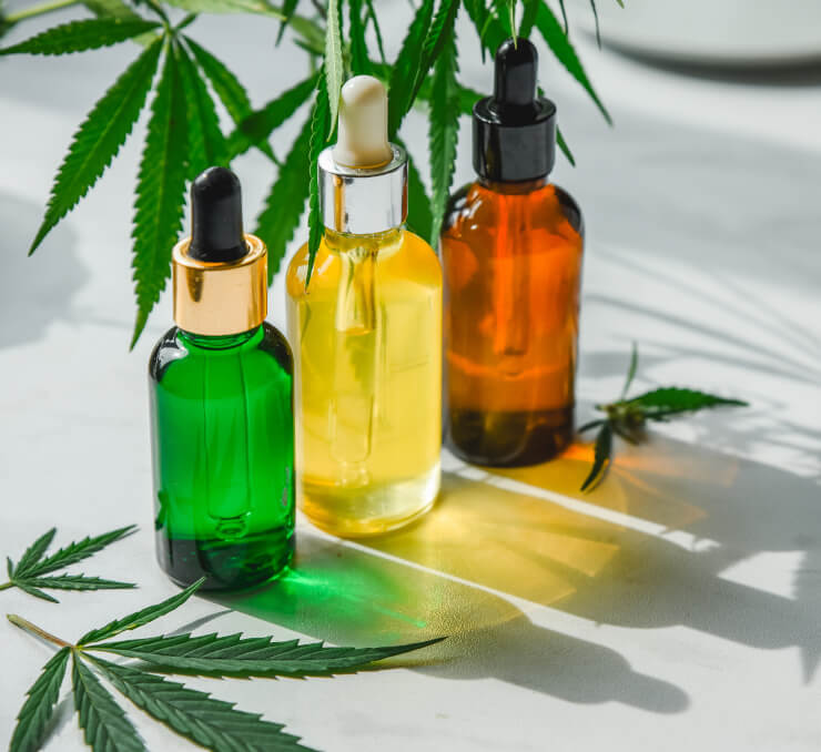 Glass bottle and dropper CBD OIL, THC tincture and cannabis leaf on background. Laboratory Production of cosmetics with CBD oil.